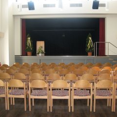 bestuhlter Saal mit Blick auf die Bühne im Bürgerhaus Müs