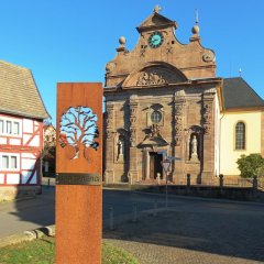 Blick auf die Stele "Lindenberg" mit der kath. Kirche St.-Georg Großenlüder im Hintergrund