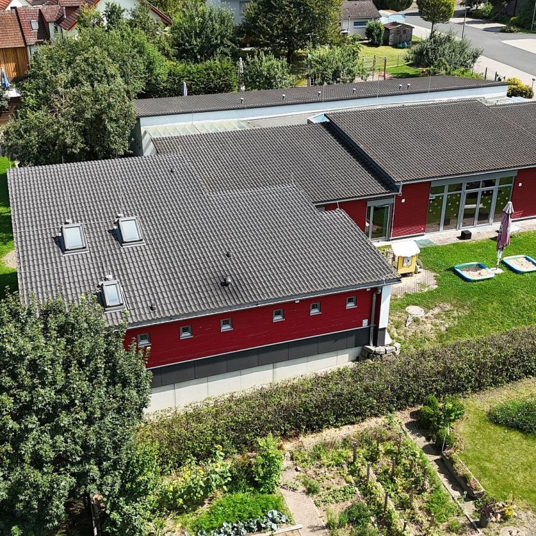 Blick von oben auf die Kath. Kita Kinderarche Kunterbunt in Bimbach mit dem Außenspielfläche