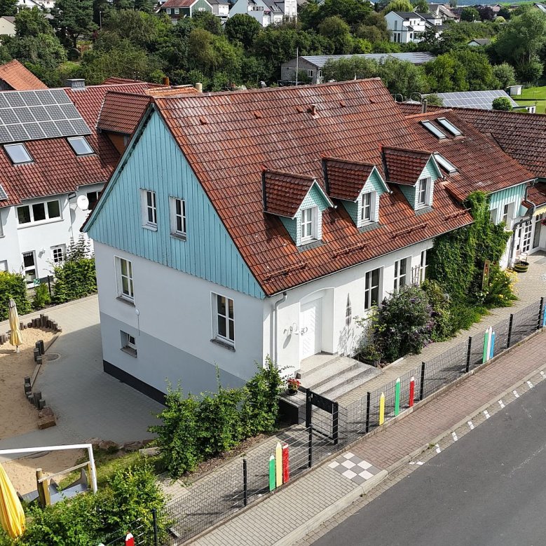 Blick von oben auf die Kita Müs mit Außenspielfläche